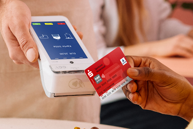 Kunde bezahlt kontaktlos mit Sparkassenkarte an mobilem Kartenlesegerät im Geschäft